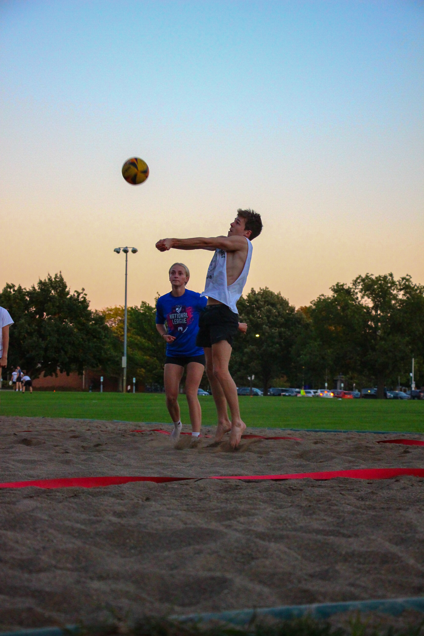 Student playing volleyball outdoors