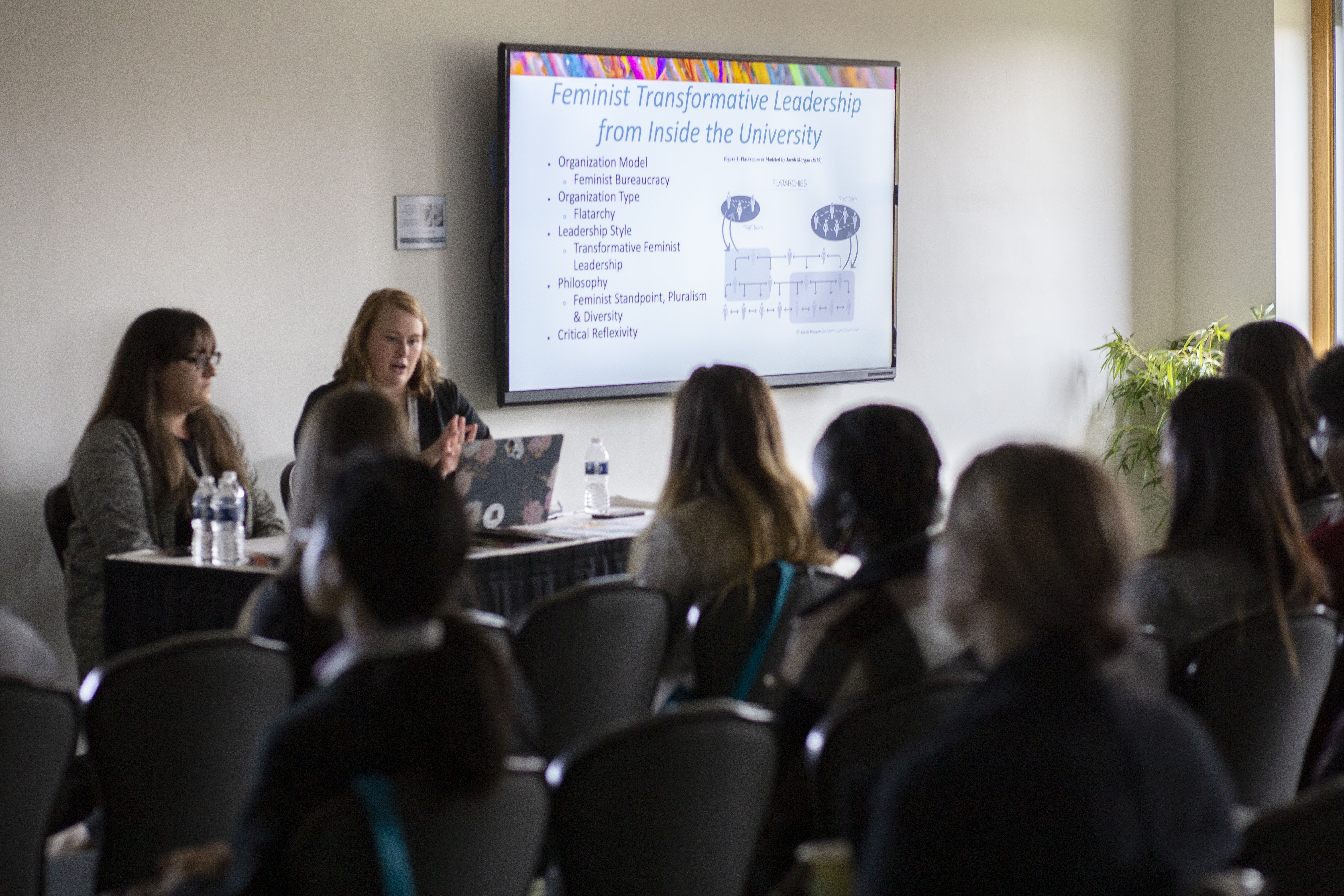 Women Giving Presentation with attendees in foreground