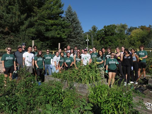 A group of students pose at a garden for Spartan Day of Service