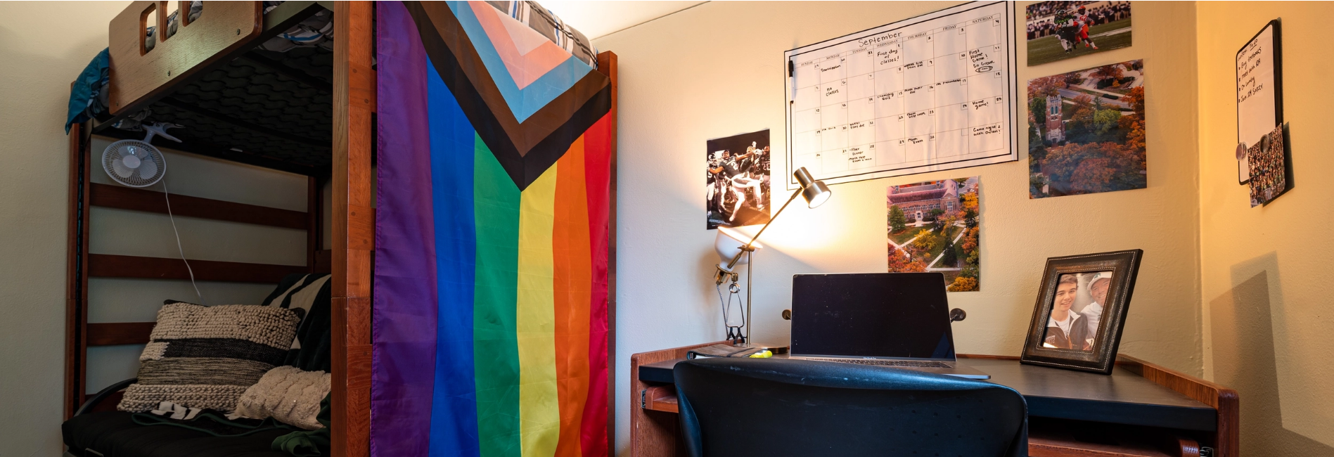 Decorated dorm room with desk, bed and displays shown prominently