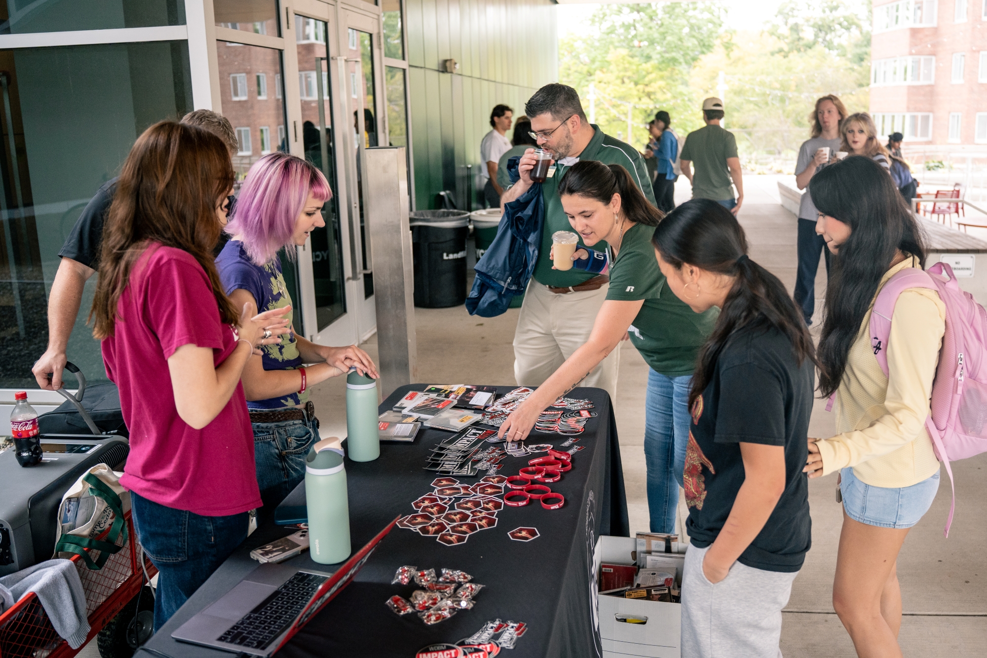 Students and staff visiting the Impact 89FM table outside the MCC