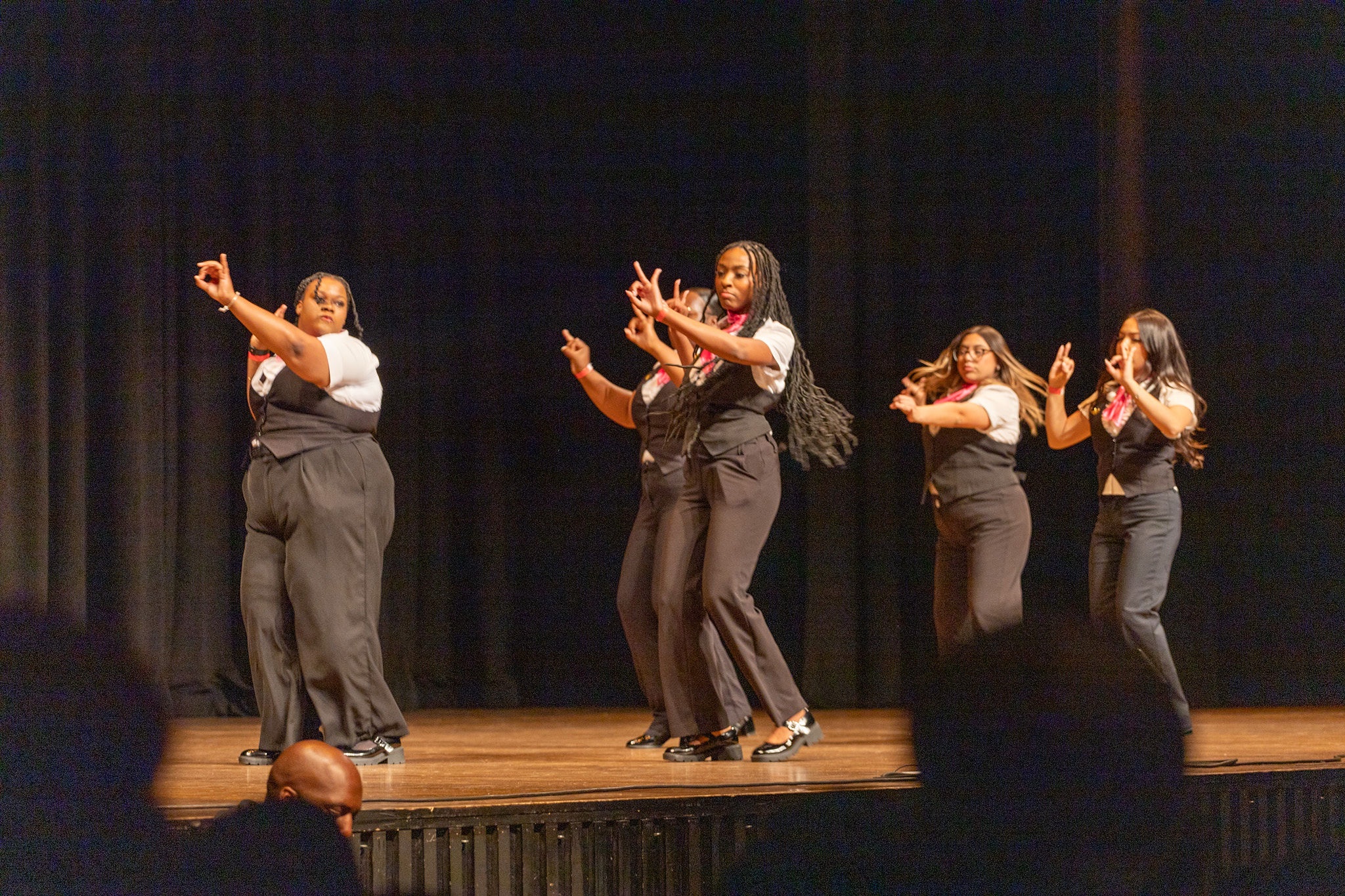 Sorority members perform in unison on stage at the Cobb Great Hall