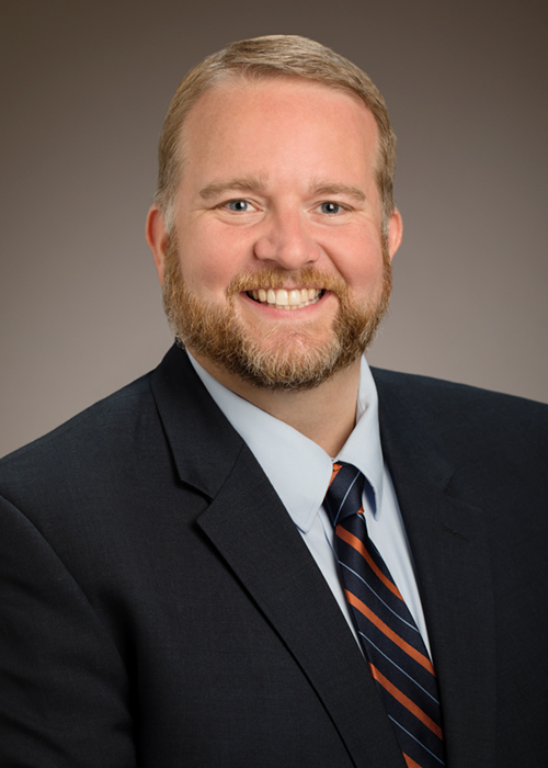 VPSA Jim Hintz sits for potrait, smiling in formal attire