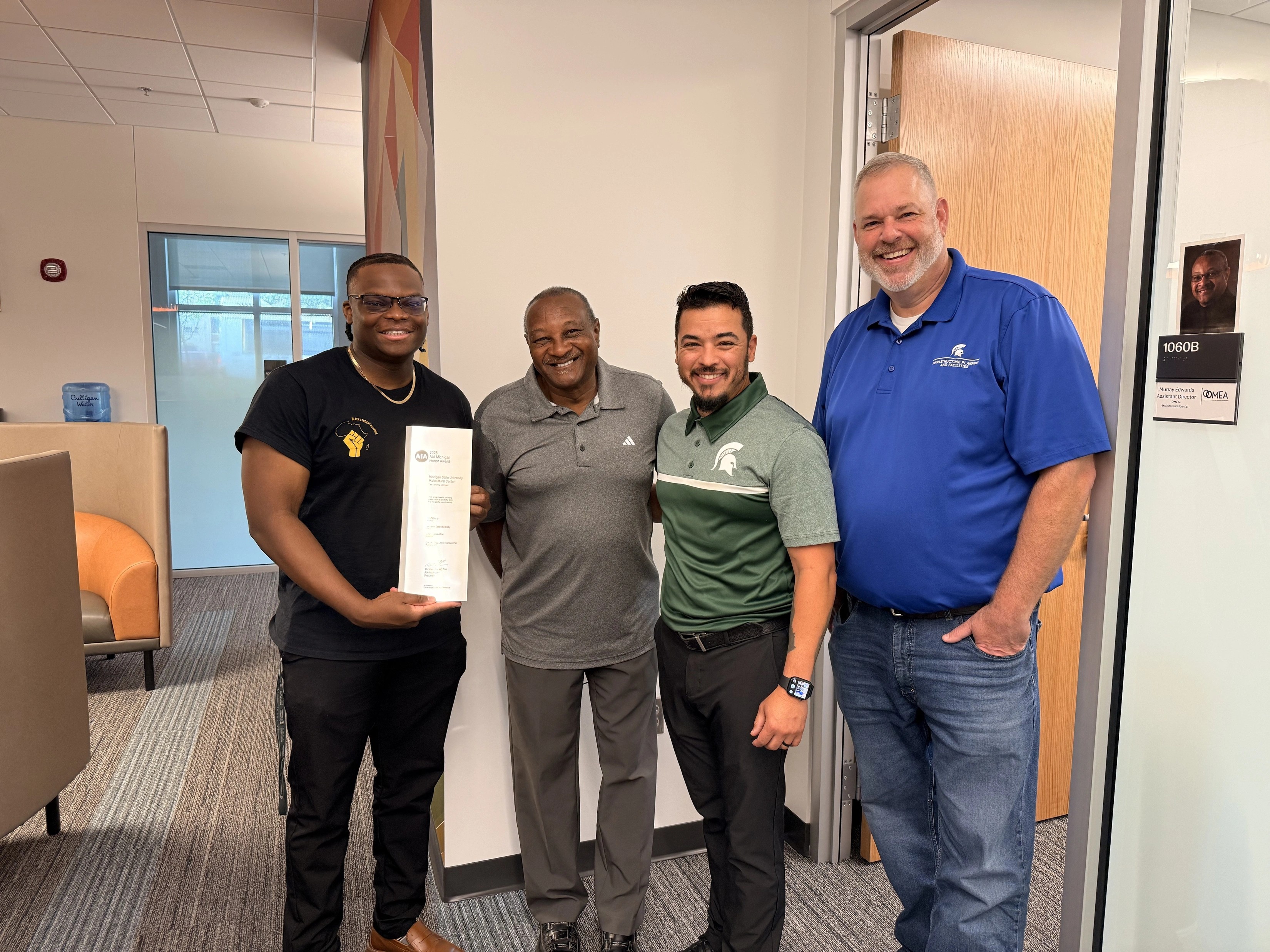 OMEA staff members holding the AIA Building Award with a member of IPF