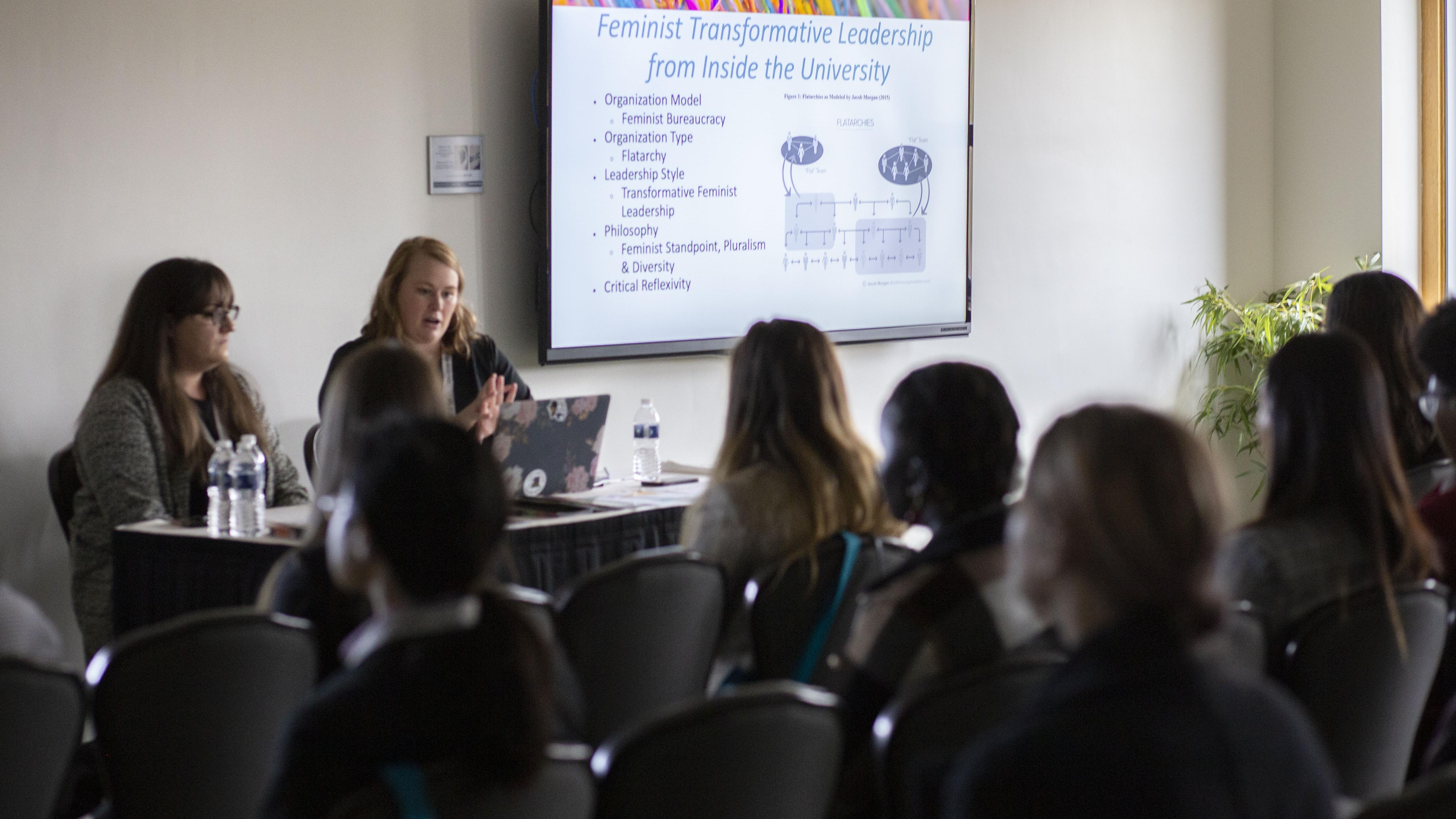 Women Giving Presentation with attendees in foreground