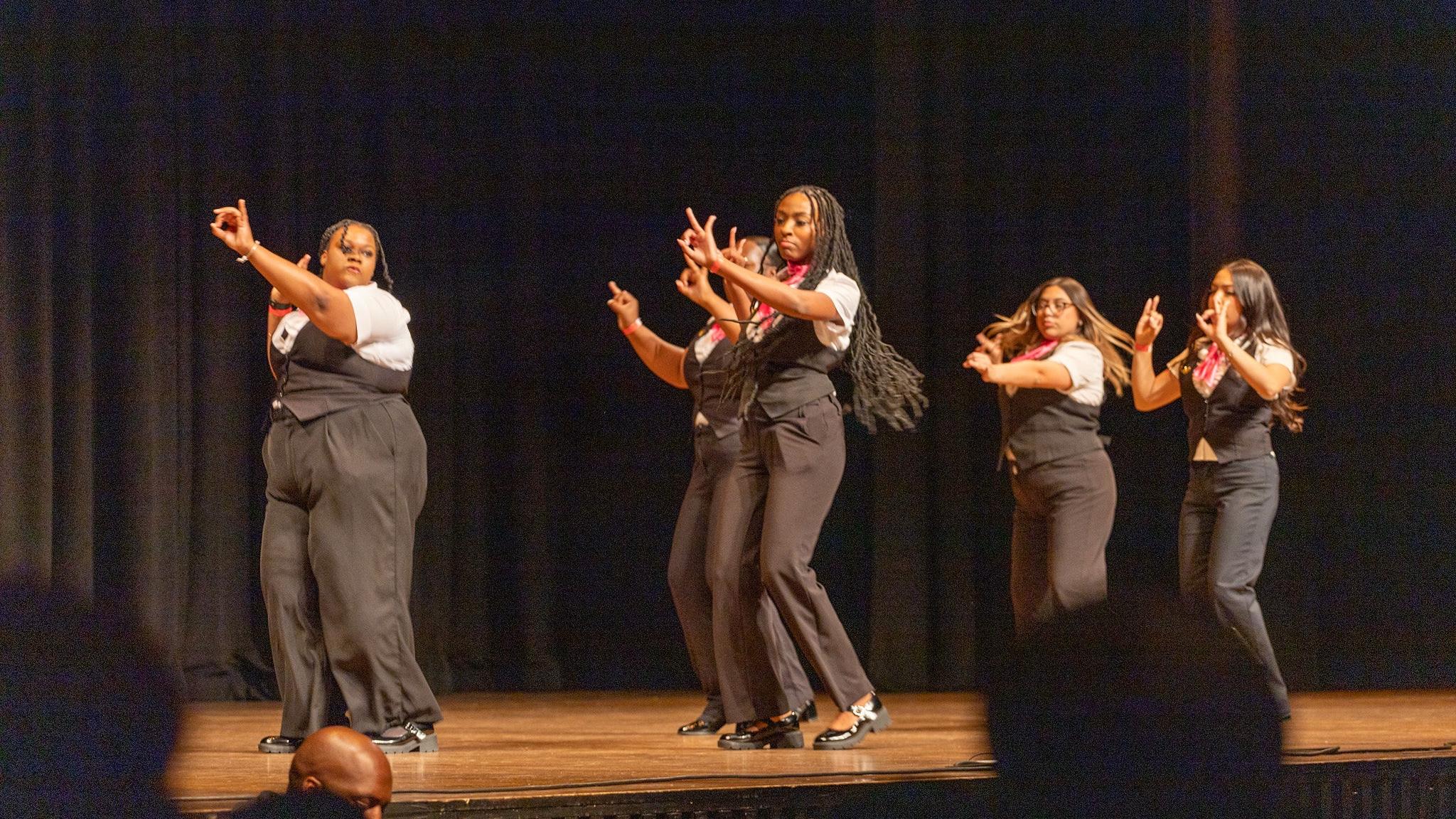 Sorority members perform in unison on stage at the Cobb Great Hall